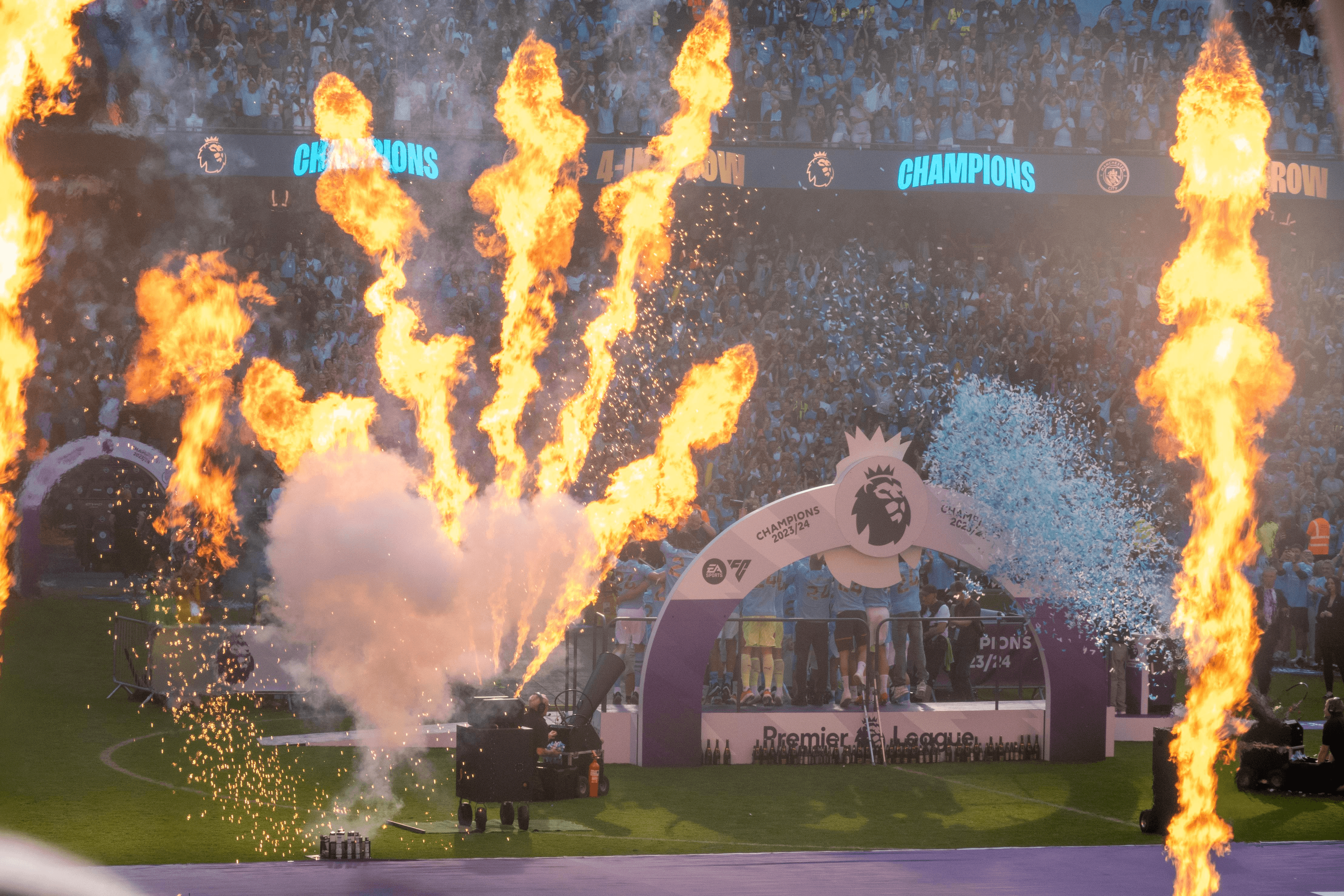 Celebratory fireworks and smoke at a sports event, with a trophy display in the background.